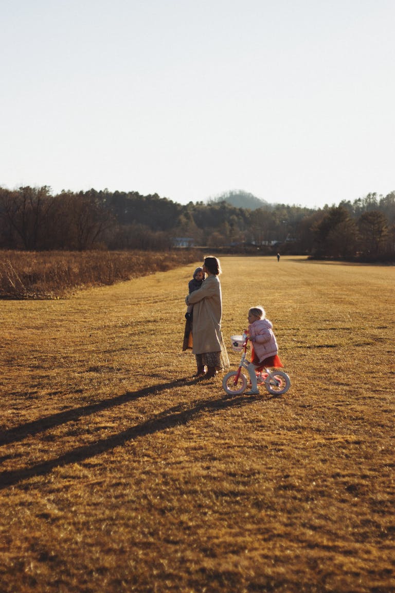 A serene moment of a mother with children in Brevard, NC's autumn landscape.